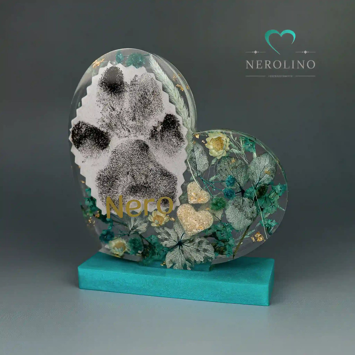 Andenken aus Harz in Herzform mit Blüten in türkis. 
