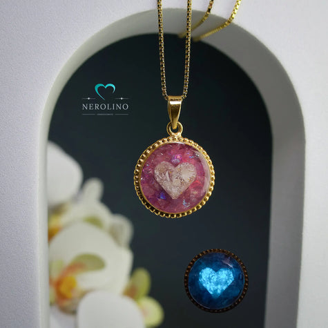 Kettenanhänger rund, verziert mit einem Herz aus Asche was im dunkeln leuchtet.