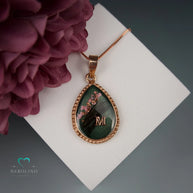 Kettenanhänger in Birnenform mit Haaren und Blüten.