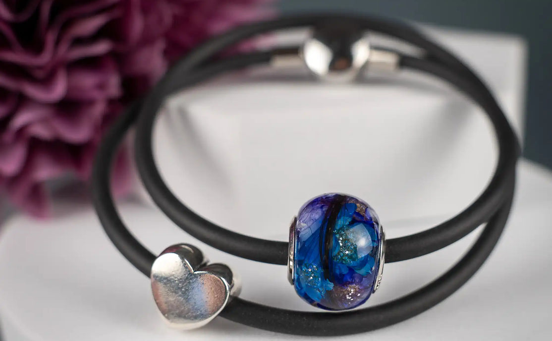 Großlochperle mit Tierhaaren und Blüten am Kautschukarmband.