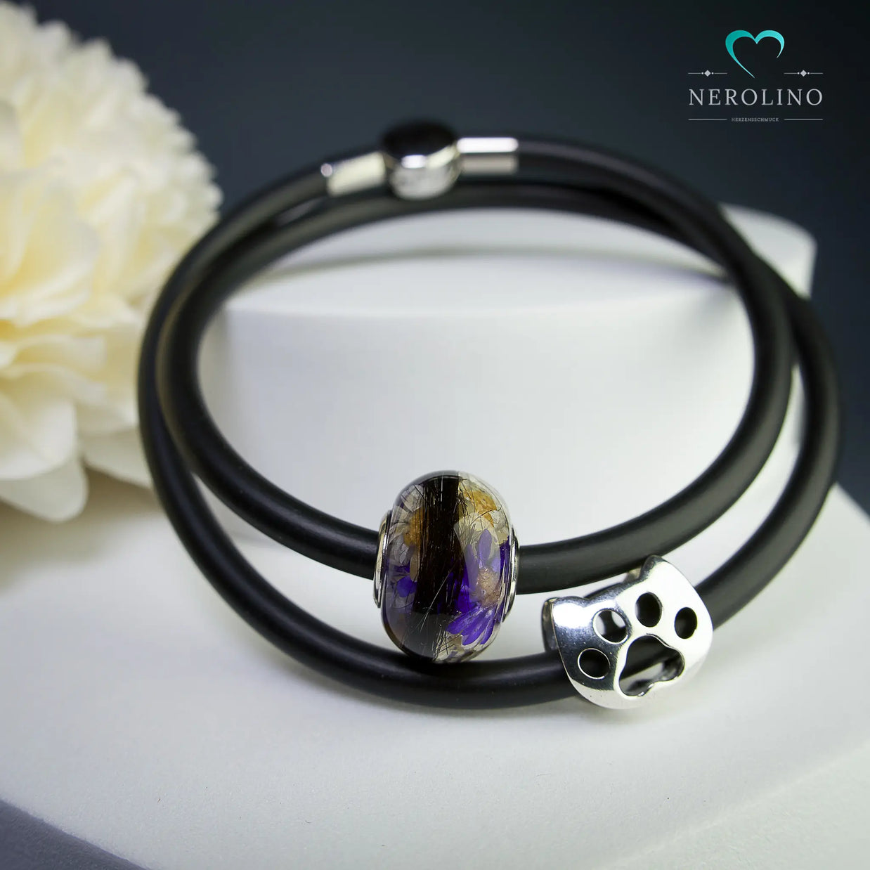 Großlochperle mit Tierhaaren und Blüten.