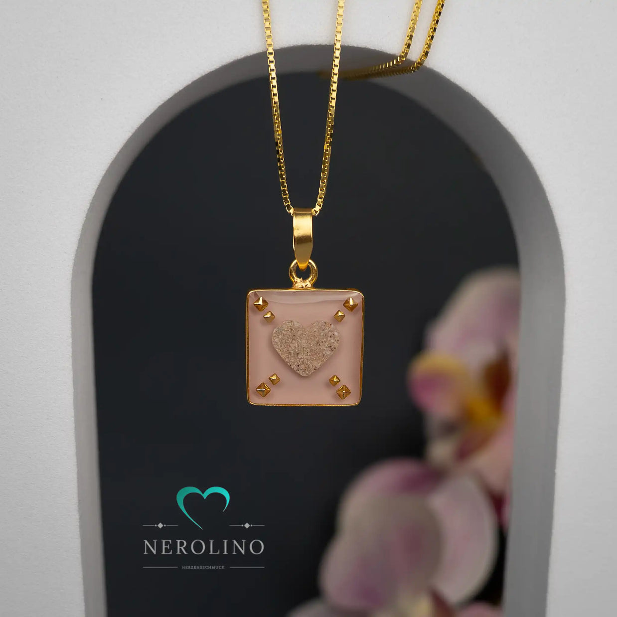 Quadratischer Kettenanhänger mit einem Herz aus Asche. 