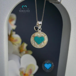 Anhänger rund mit Asche und einem Herz aus Leuchtpulver in Sterlingsilber. 