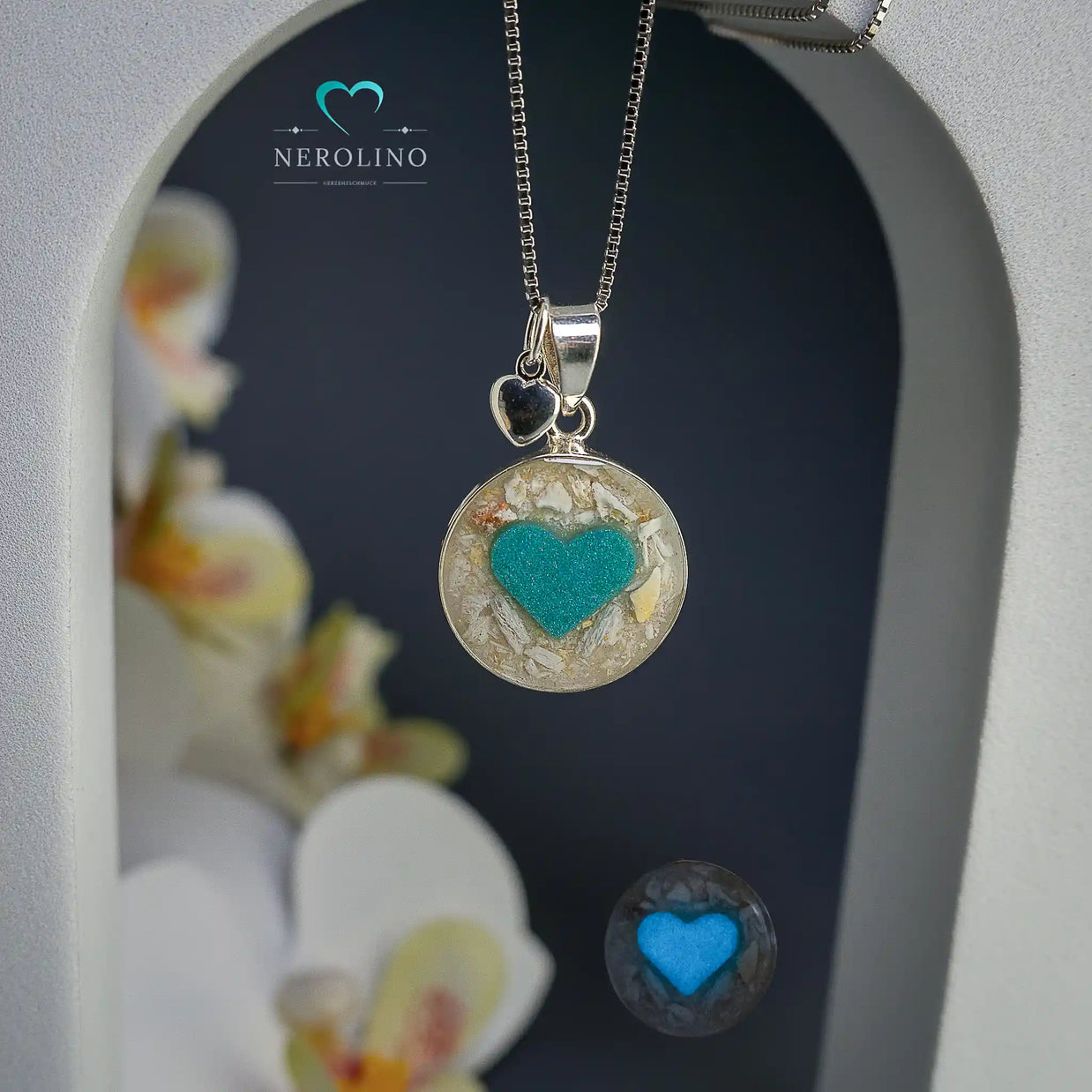 Anhänger rund mit Asche und einem Herz aus Leuchtpulver in Sterlingsilber. 