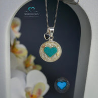 Anhänger rund mit Asche und einem Herz aus Leuchtpulver in Sterlingsilber. 