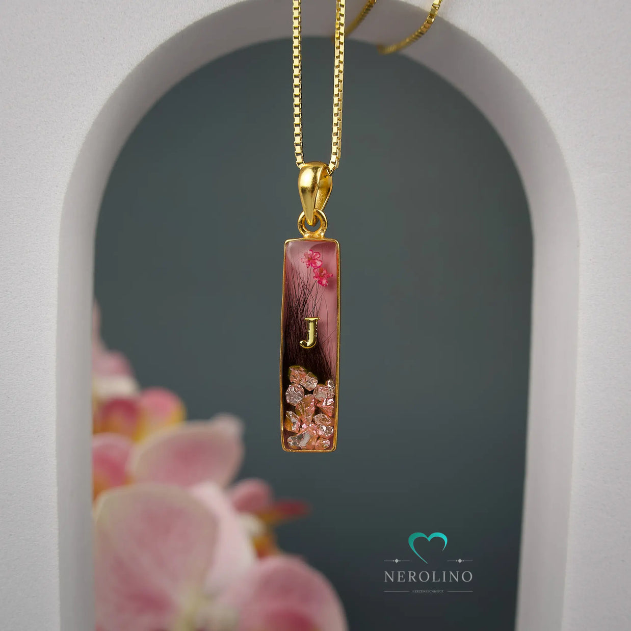 Kettenanhänger rechteckig mit Haaren und Blüten. 