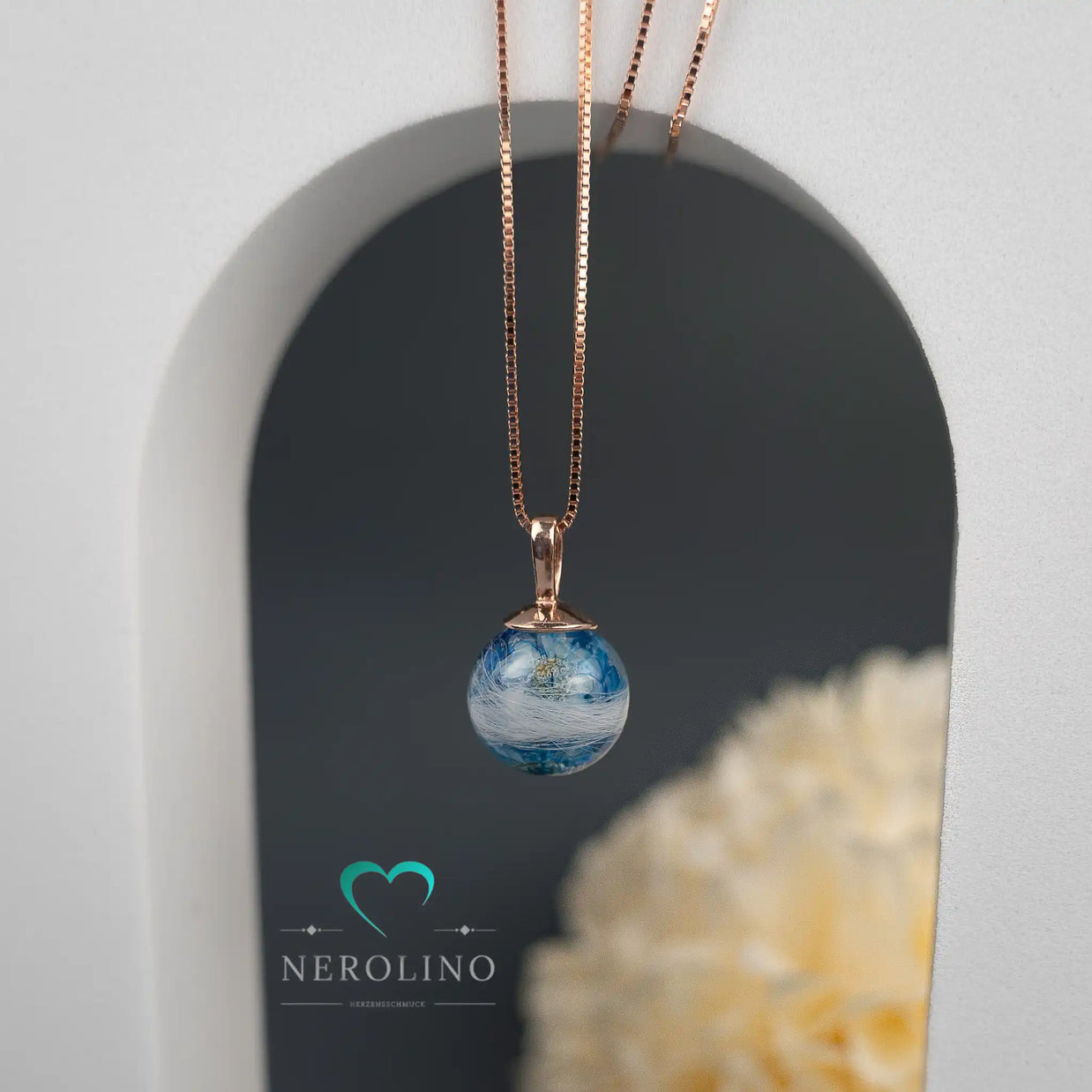 Perlenanhänger mit Tierhaaren und Blüten in blau. 