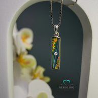 Kettenanhänger rechteckig mit Haaren und Blüten.