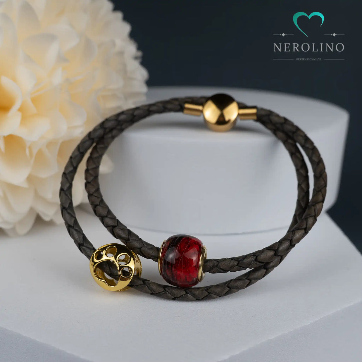 Großlochperle mit Tierhaaren und Blüten in Gold am Lederarmband.