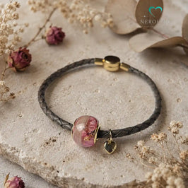 Perle mit rosa Blüten und weißem Hundefell am Lederarmband.