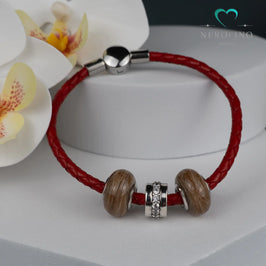 Grosslochperlen mit Haaren in der Farbe silber am roten Kunstlederarmband. 